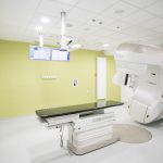 Sala zabiegowa z ustawioną na środku maszyną do leczenia